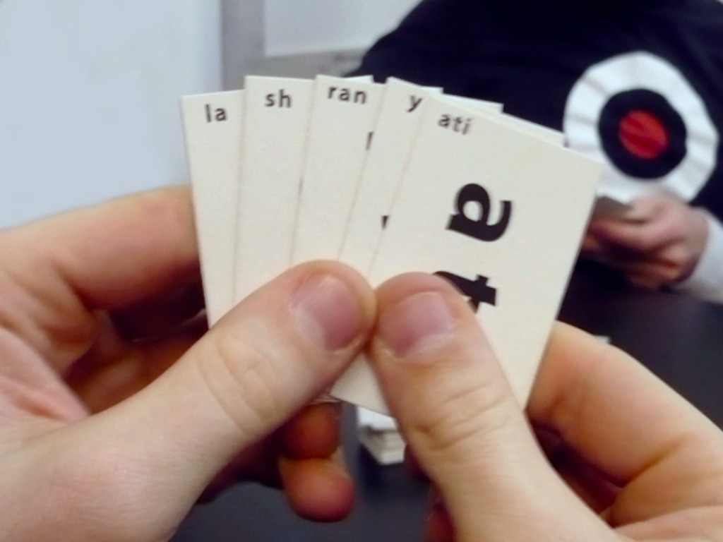 Hand of cards labelled “la,” “sh,” “ran,” “y,” and “ati”